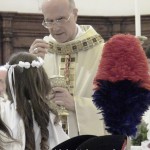 Il cardinale Bertone dà l'Eucarestia ai ragazzi della Prima Comunione