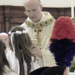 Il cardinale Bertone dà l'Eucarestia ai ragazzi della Prima Comunione